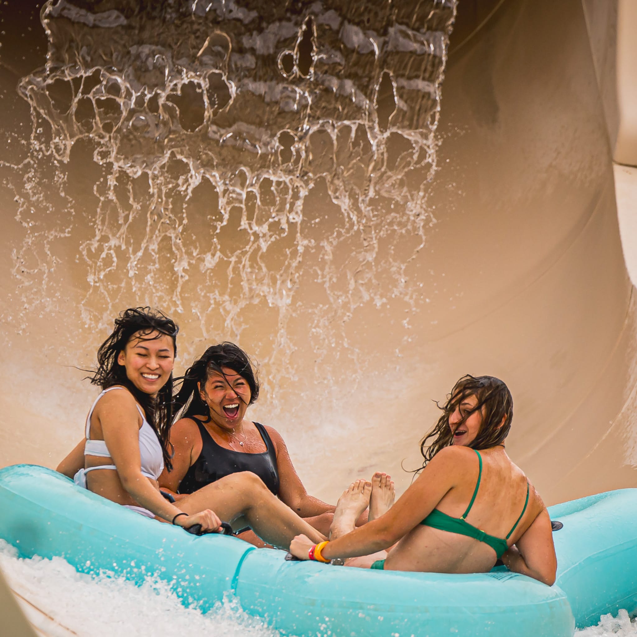 3 personnes qui glissent dans une tube pour 4 personnes dans une glissade fermée beige