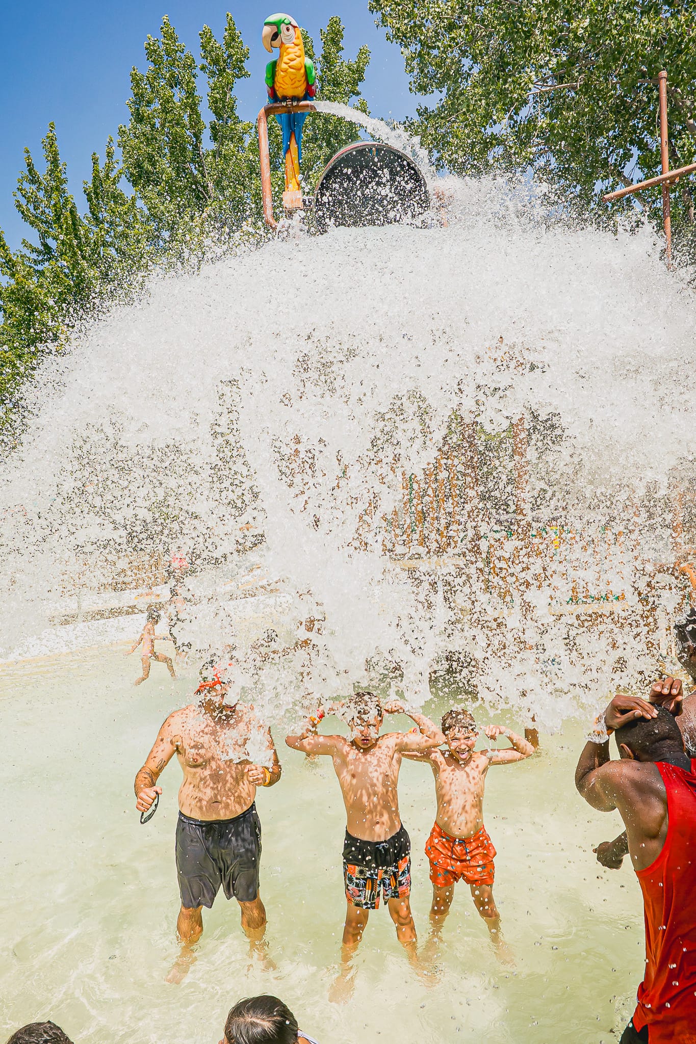 2 garçons et 1 homme qui se font arroser par le seau d'eau de l'île du pirate