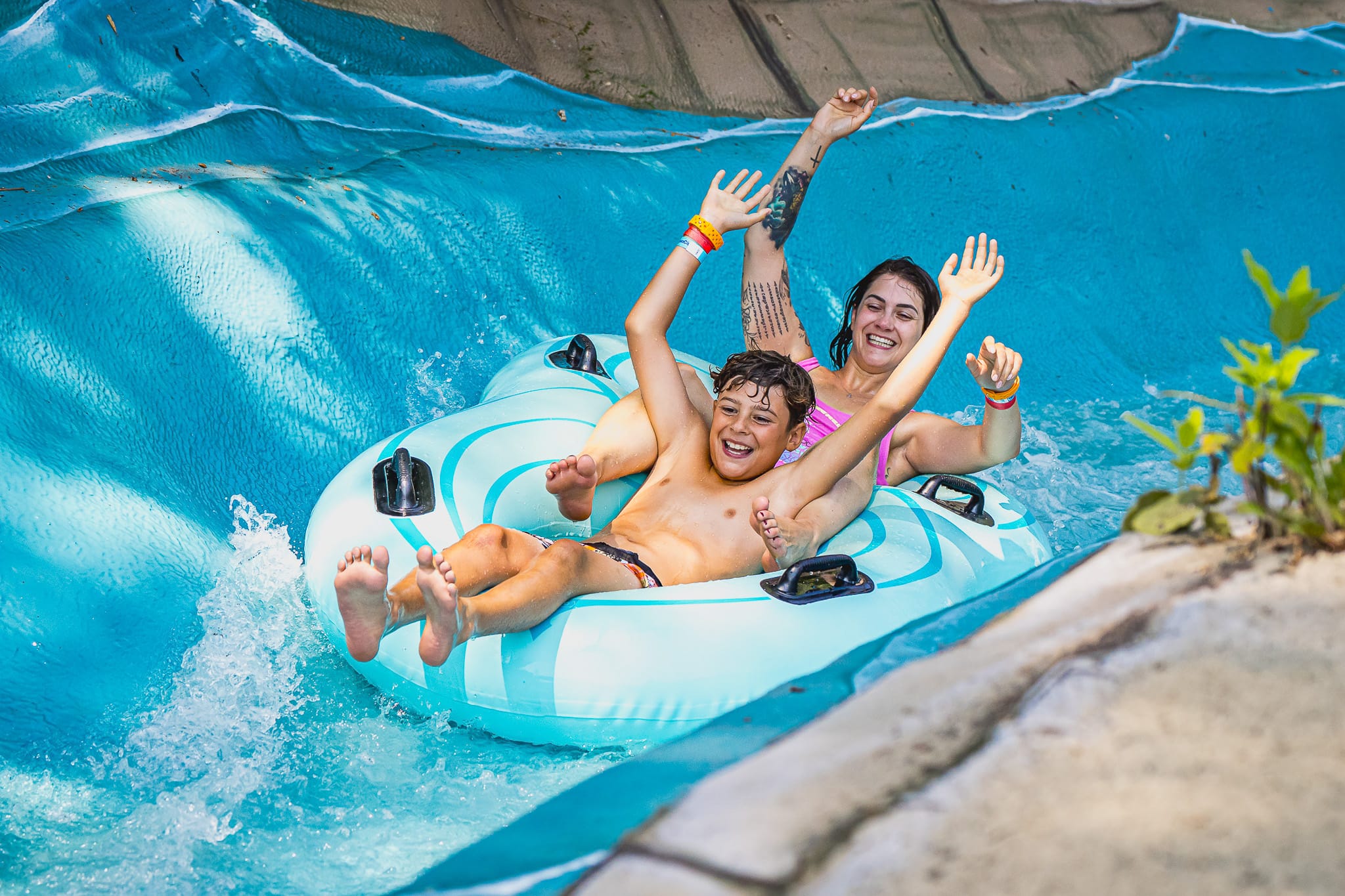 Une femme et son enfant qui glisse dans un tube à deux personnes