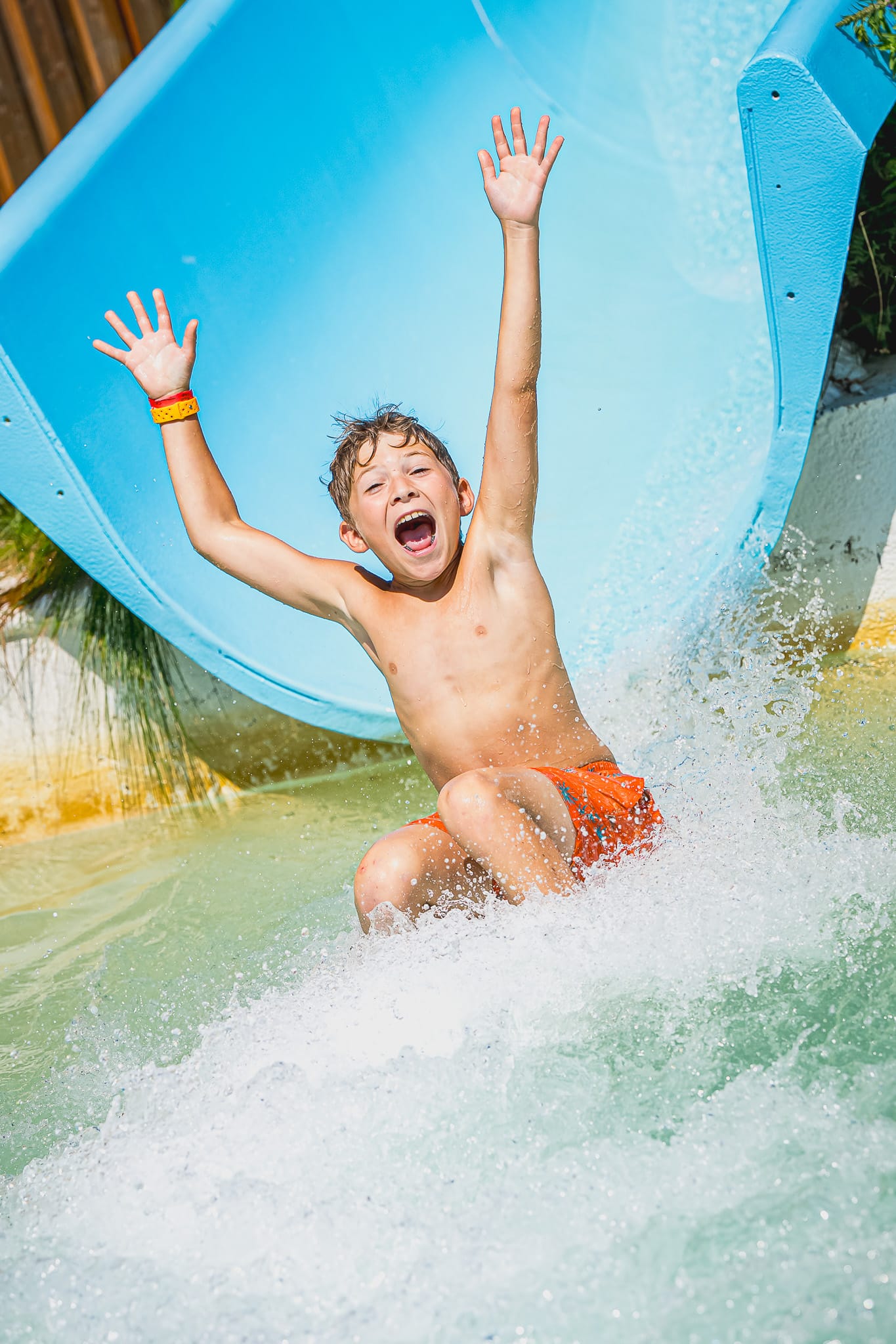 Un garçon content qui glisse une glissade
