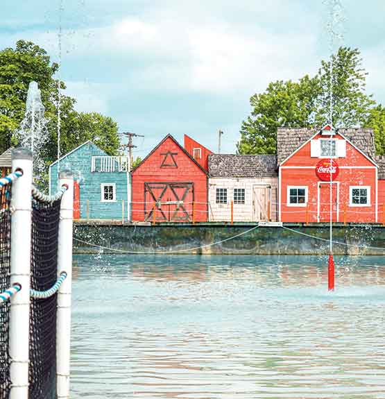Grand bassin d'eau avec jets, maisons et clotures