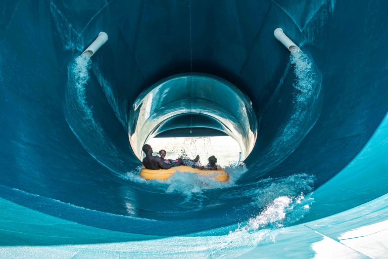 Famille glissant dans la Tornade, une grande glissade bleue