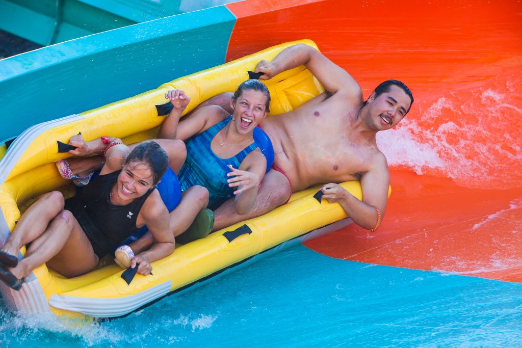 trois personnes qui glissent dans un tube dans le Tsunami