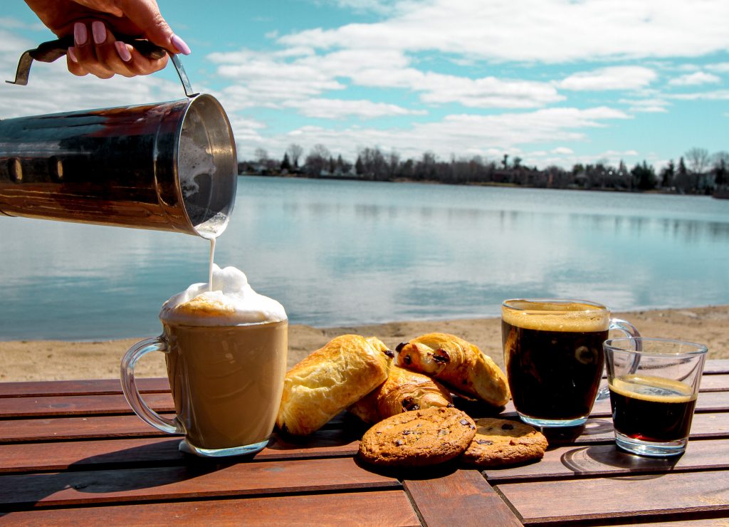Café et viennoiserie devant un lac