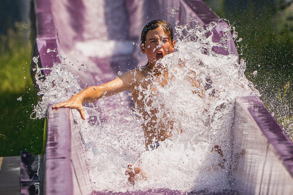 un garçon qui glisse dans une glissade mauve