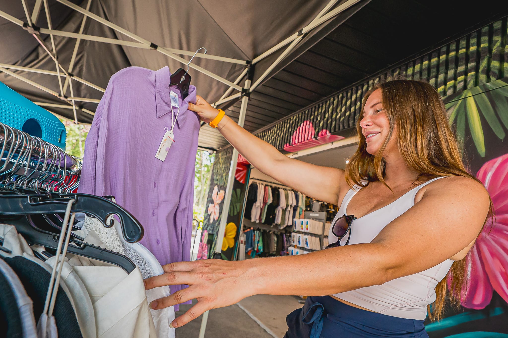 Une personne qui magasine un chandail mauve