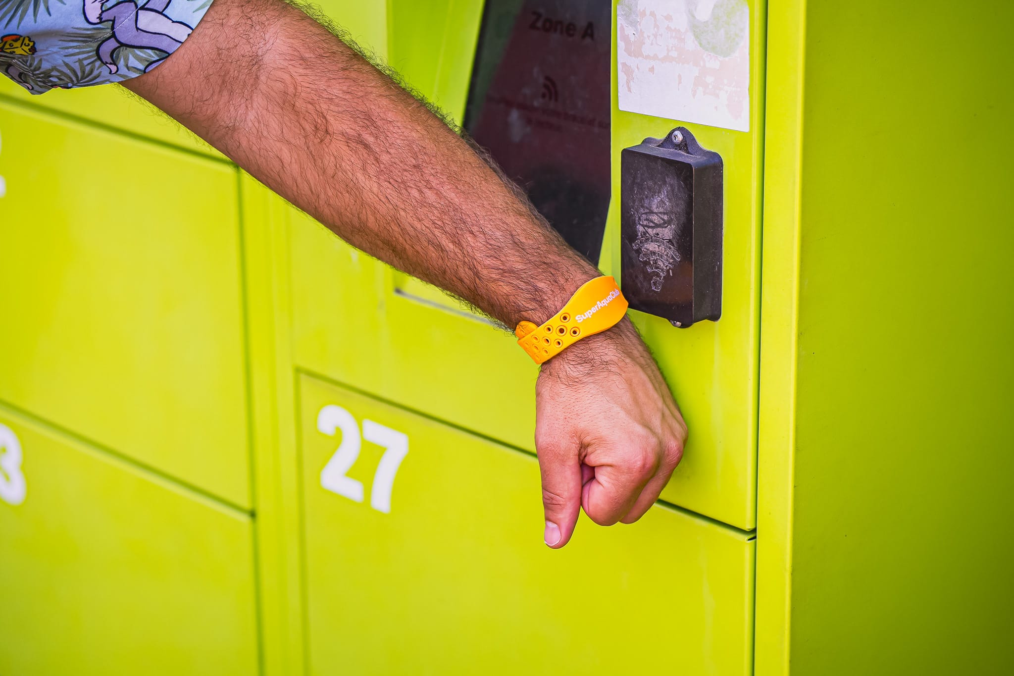 Une personne qui scanne son bracelet connecté pour ouvrir son casier