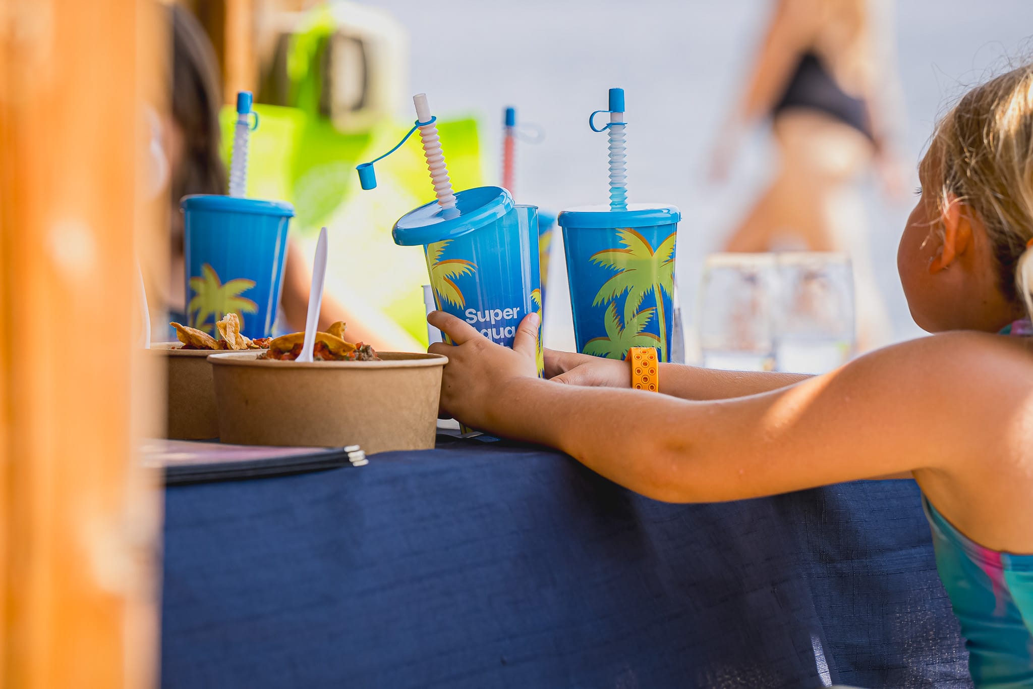 Trois verres Super Aqua Club avec une petite fille de dos